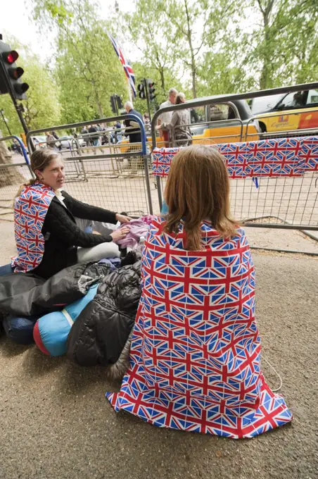 England, London, The Mall. A mother and daughter wearing Union Jack capes camped on The Mall in preparation for the Royal Wedding the following day.