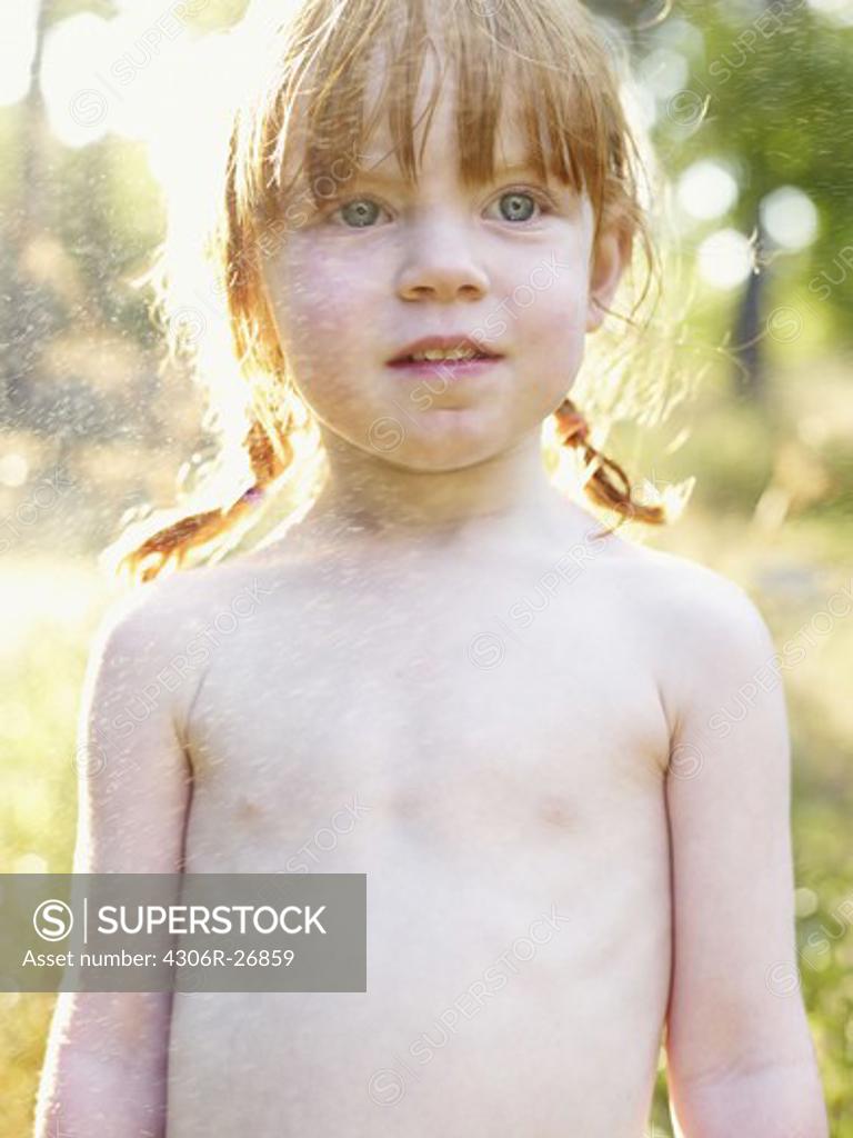 Portrait of shirtless girl sprinkled with water - SuperStock