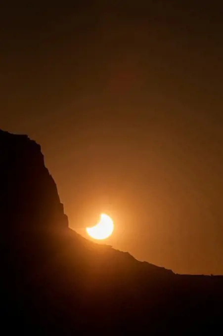 The partially-eclipsed sun sets behind a butte in Monument Valley Tribal Park, on the Utah-Arizona border, following an annular eclipse of the sun on May 20, 2012.