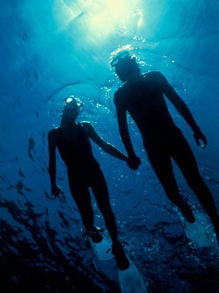 Silhouette of a Man and Woman Snorkeling