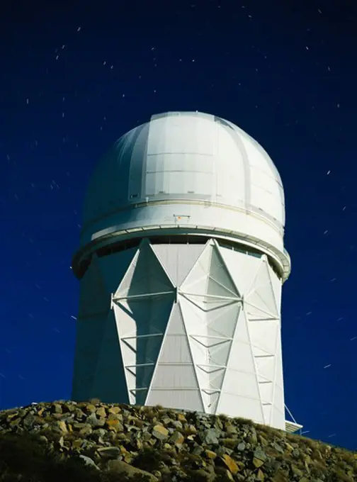 Stars rotating around Polaris, the North Star, at the apex of the 4-meter Mayall Telescope Building on top of Kitt Peak, Kitt Peak National Observatory, Arizona.