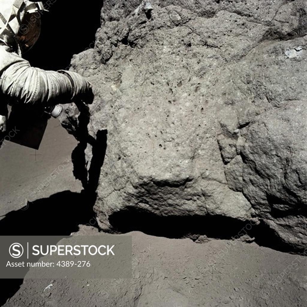 Stock Photo: 4389-276 An Apollo 17 Astronaut Examines and Takes Samples From a Moon Rock