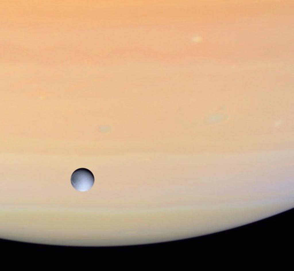 Dione and Saturn Seen by Cassini