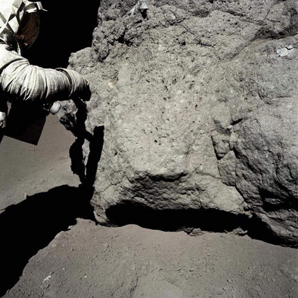 An Apollo 17 Astronaut Examines and Takes Samples From a Moon Rock