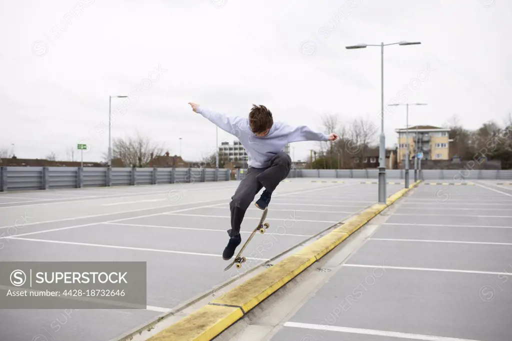 Teenage boys skateboarding in parking lot