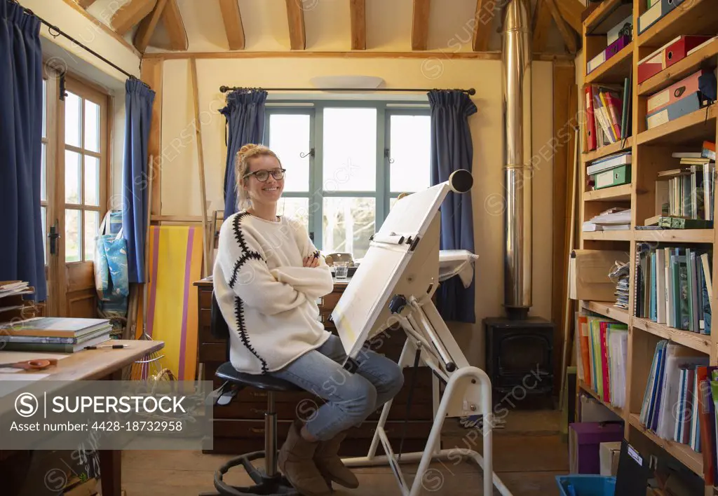 Portrait female architect working at drafting table in home office