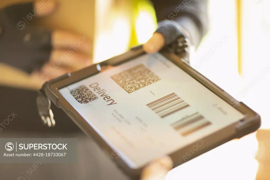 Close up courier holding digital tablet with delivery QR codes