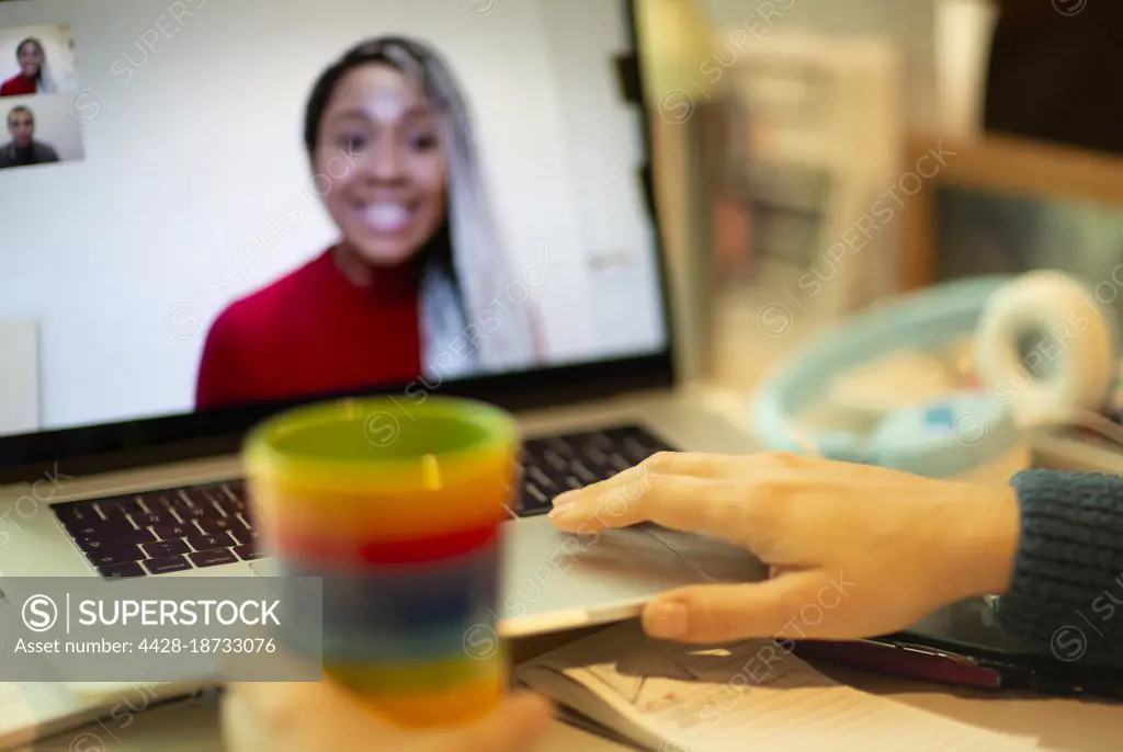 Woman video chatting with colleagues at laptop screen
