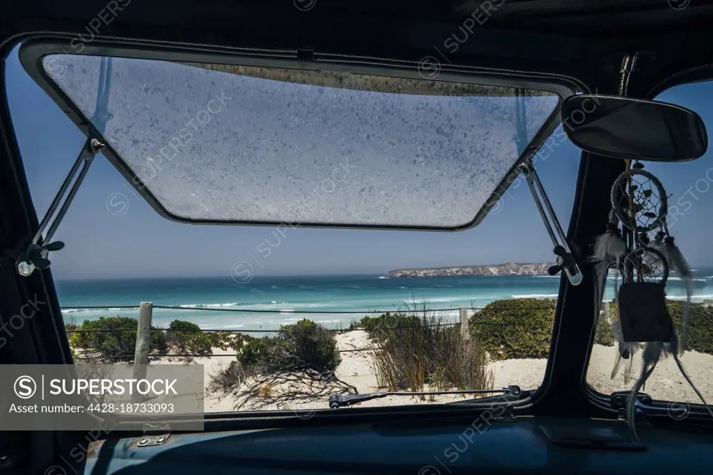 Bus window open to sunny scenic idyllic ocean seascape