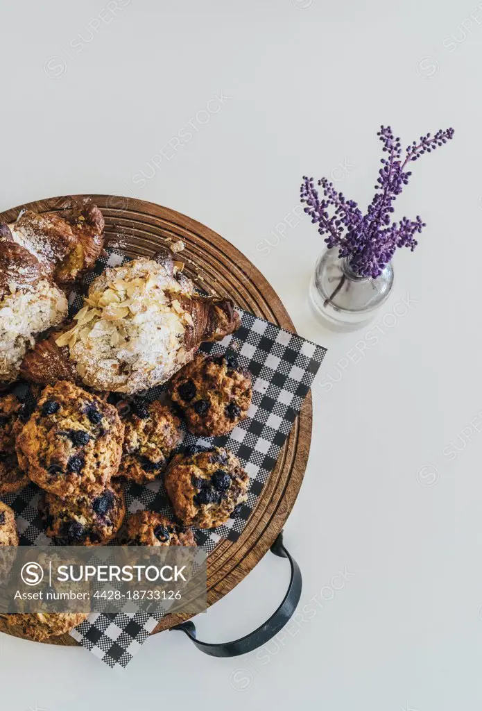 Still life muffins and croissants on tray on white background