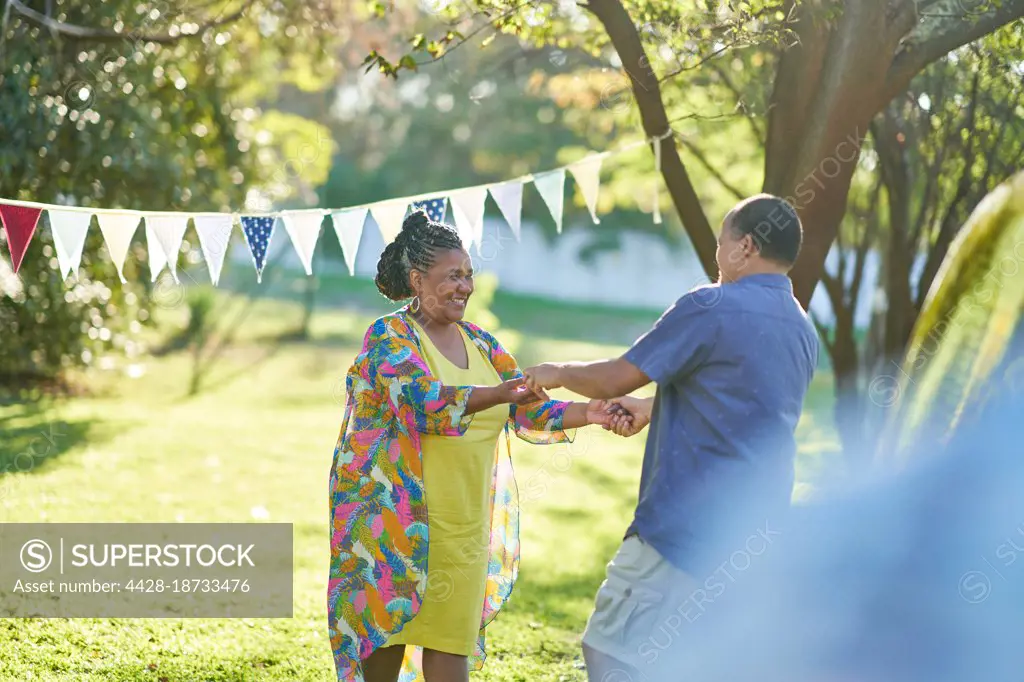 Happy couple dancing in summer park