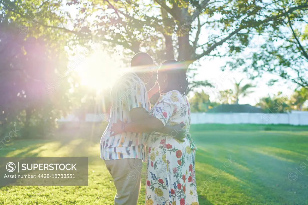 Happy couple dancing in sunny summer backyard