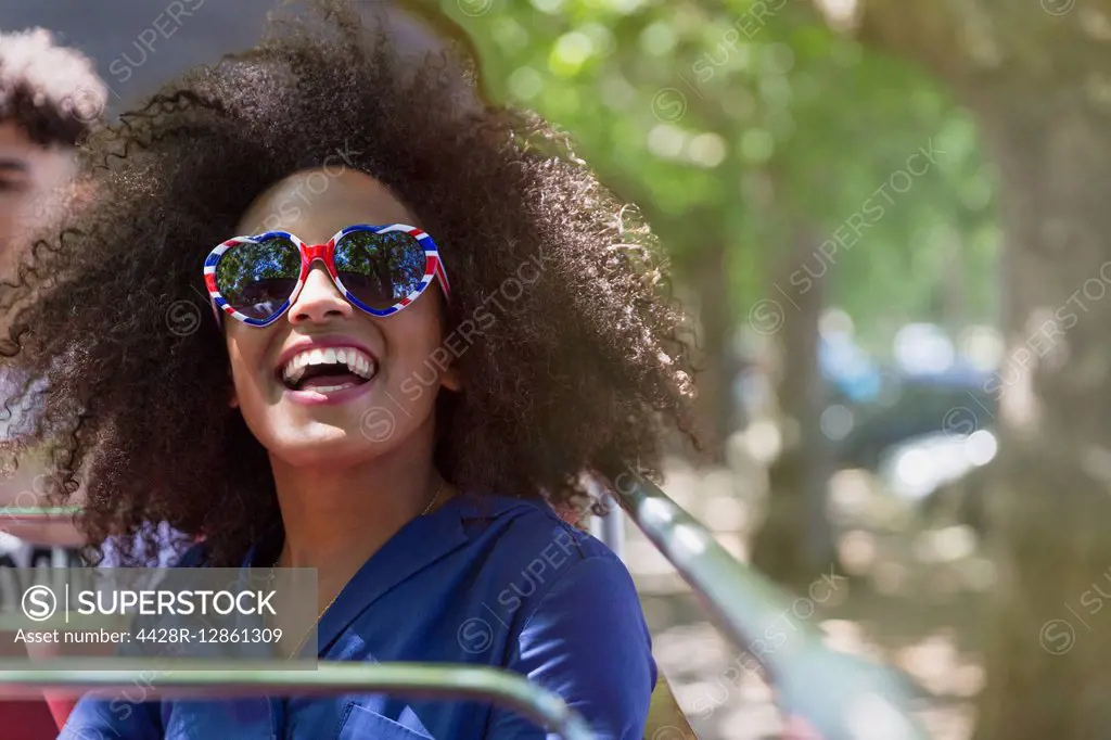 Enthusiastic woman with afro wearing heart-shape glasses