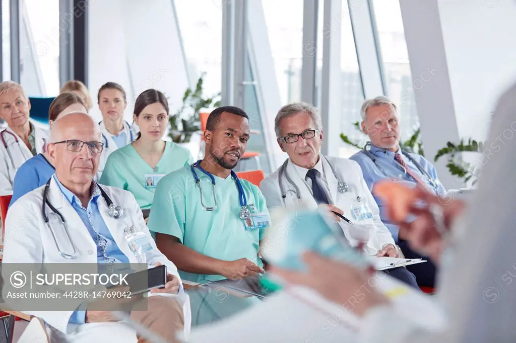 Surgeons, doctors and nurses listening in conference audience
