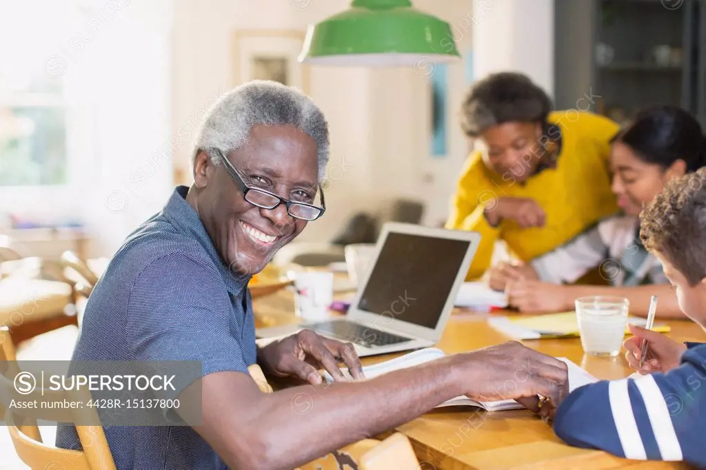 Portrait smiling, confident senior man using laptop with family
