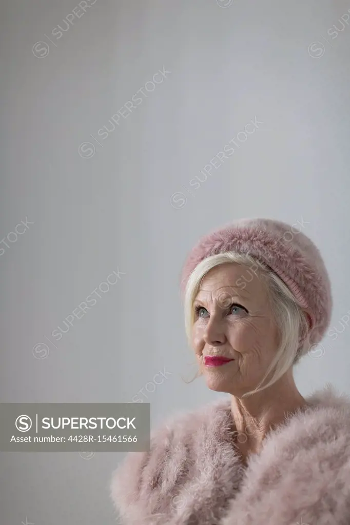 Portrait confident, elegant senior woman wearing pink fur