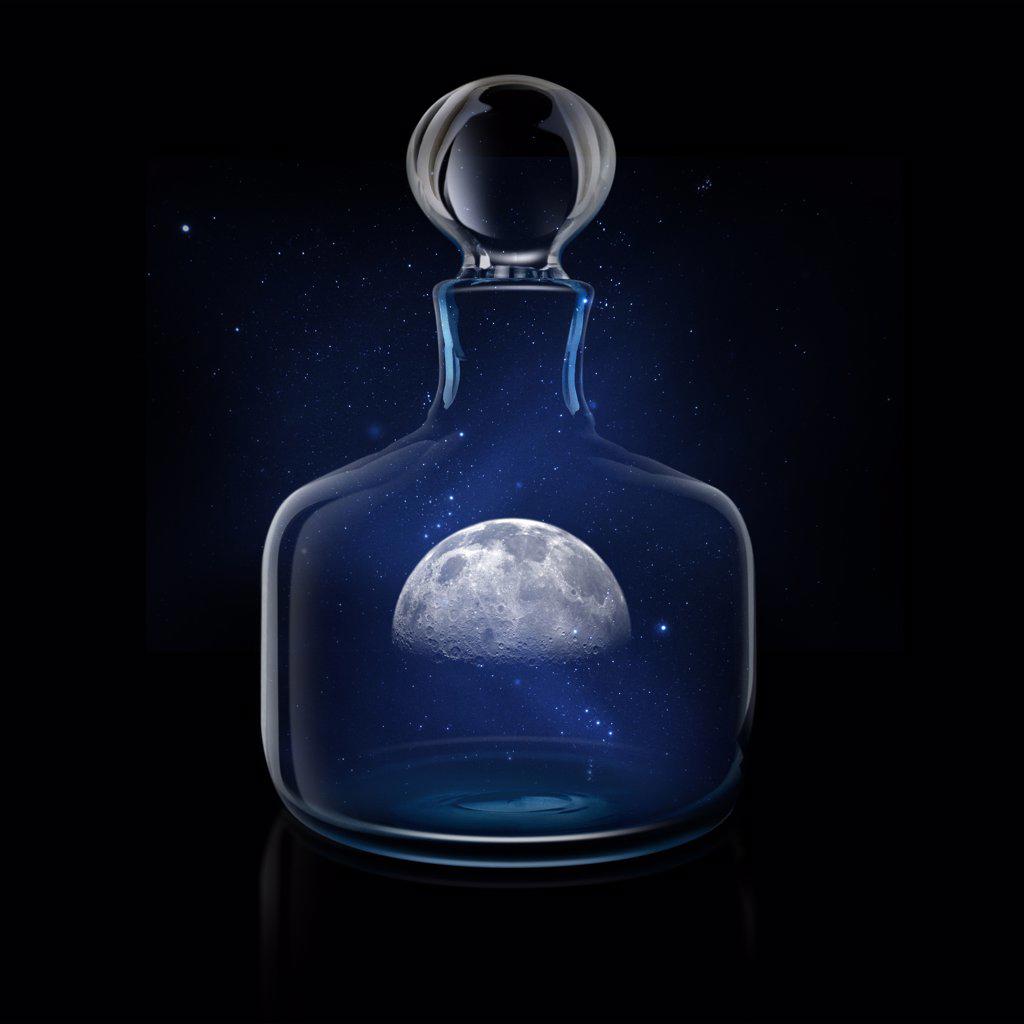 Mysterious moon in glass decanter against night sky