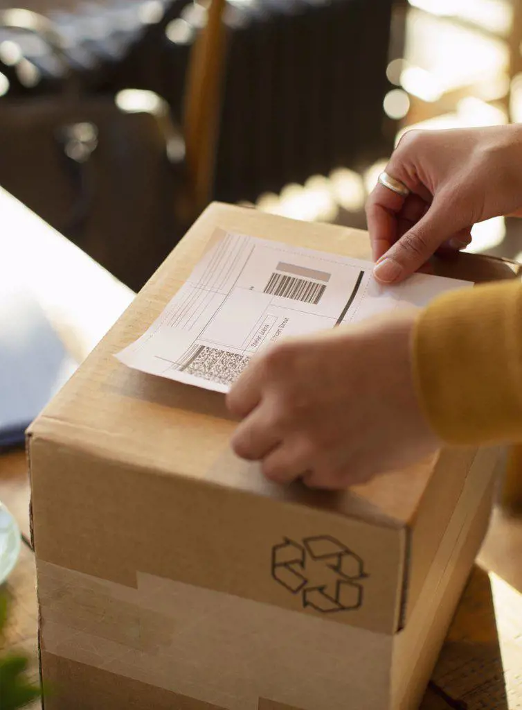 Close up business owner placing shipping label on box