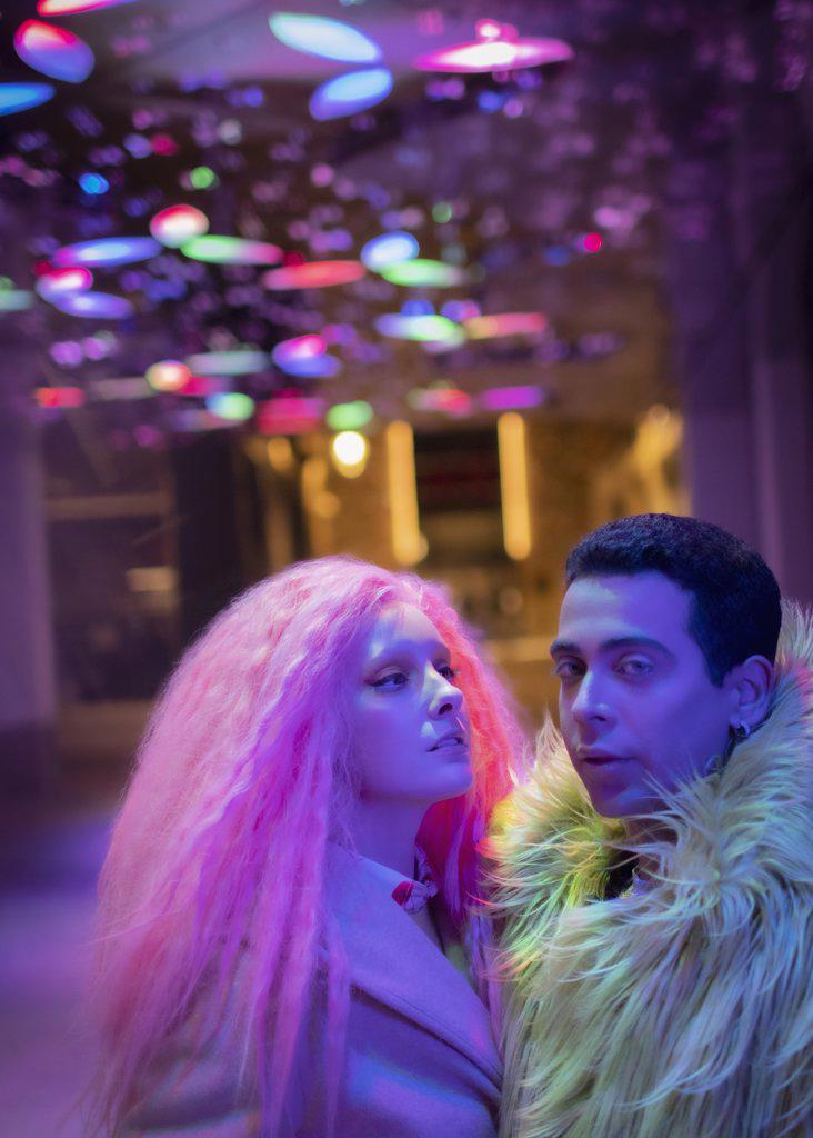 Portrait cool fashionable couple under neon lights