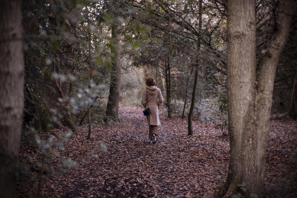 Young woman walking in autumn woods