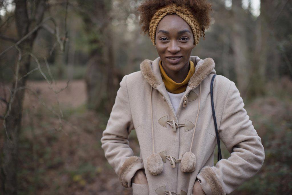 Portrait happy young woman in coat in autumn woods