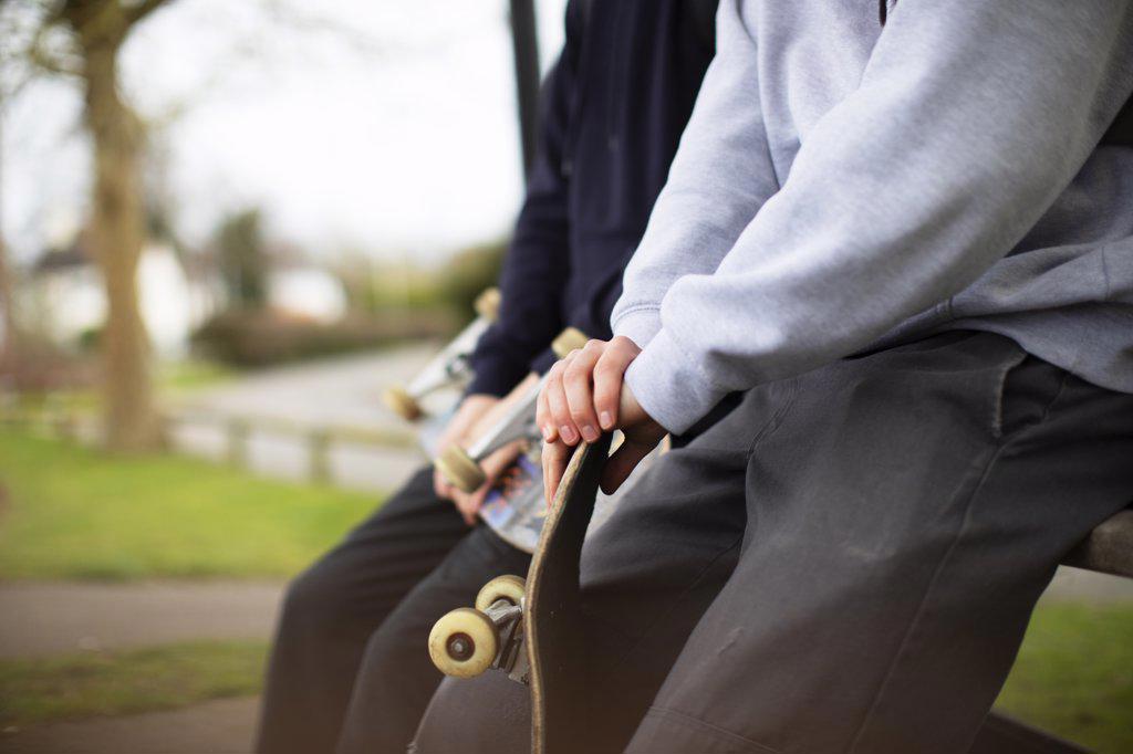 Close up teenage boys with skateboards in park