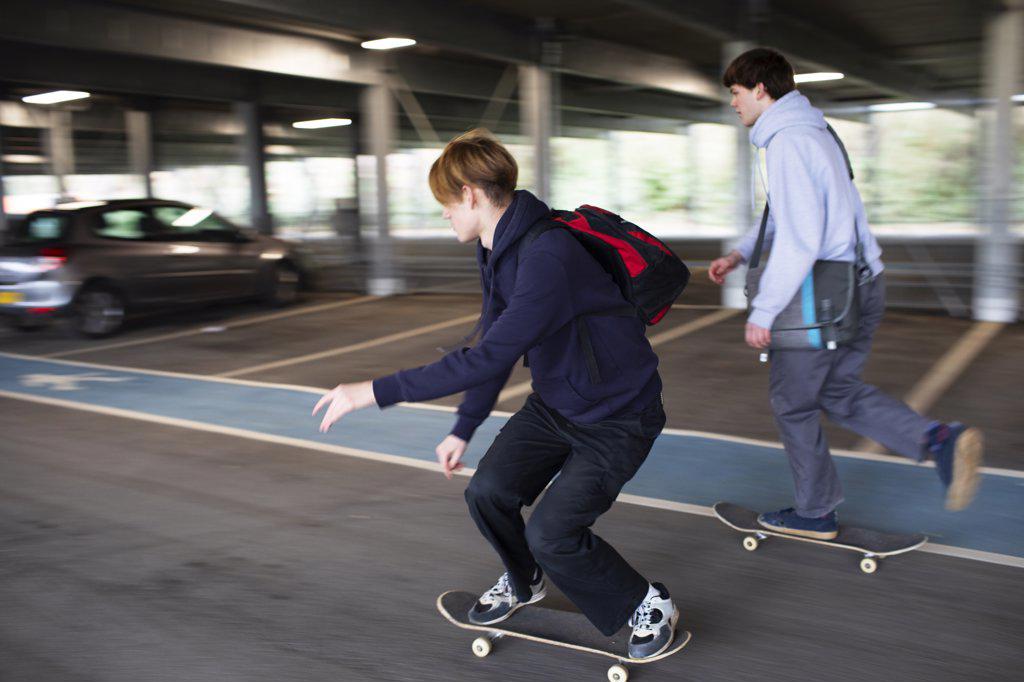 Teenage boys skateboarding in car park