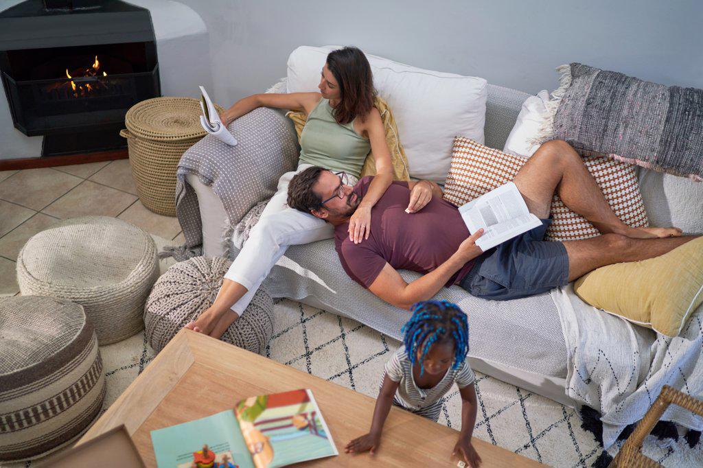 Family relaxing and reading on living room sofa