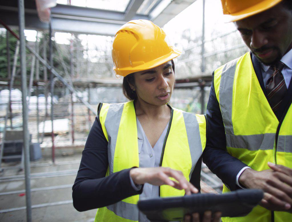 Architects with digital tablet at construction site
