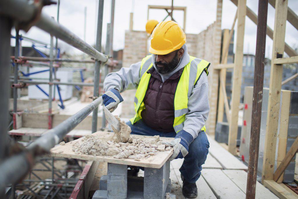 Male construction worker mixing concrete at construction site