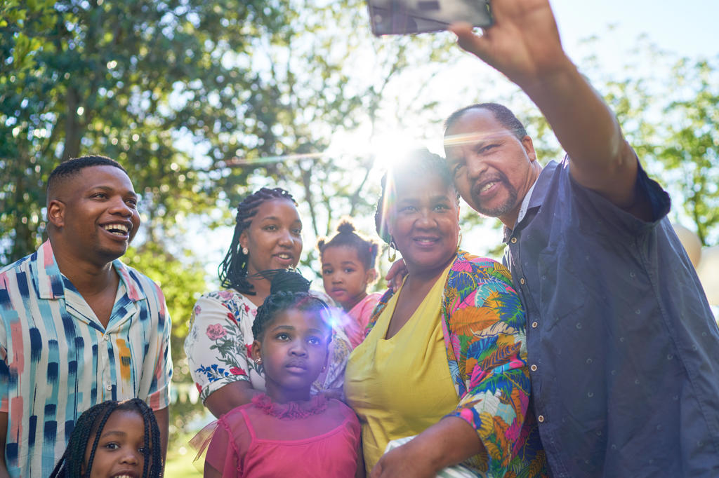 Happy multigenerational family taking selfie in sunny park