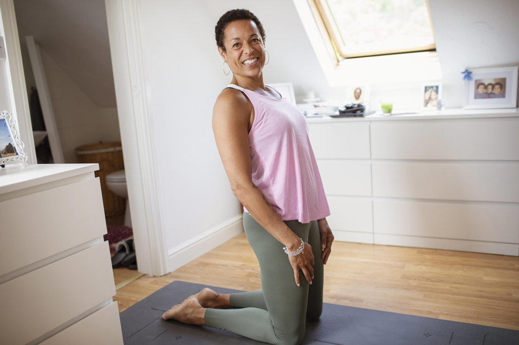 Portrait confident woman exercising on yoga mat at home