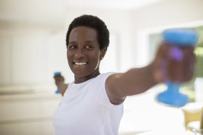 Confident senior woman exercising with dumbbells