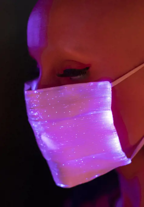 Close up fashionable woman in shimmery pink face mask