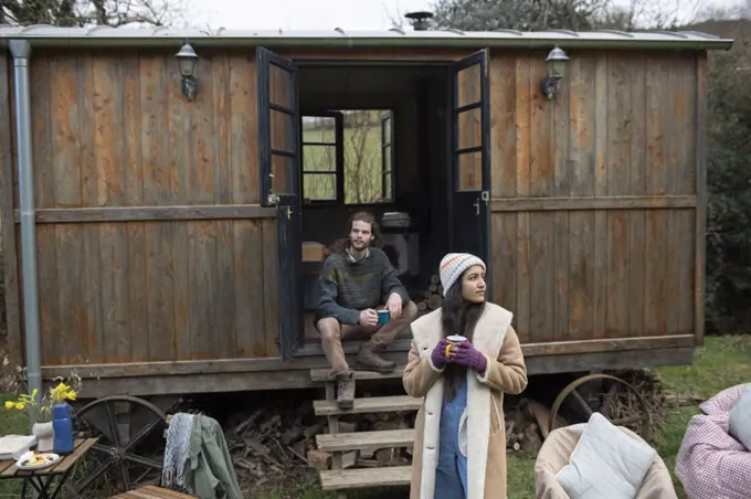 Couple enjoying coffee outside tiny cabin rental