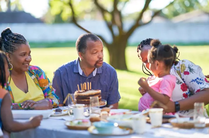 Multigenerational family celebrating birthday at patio table