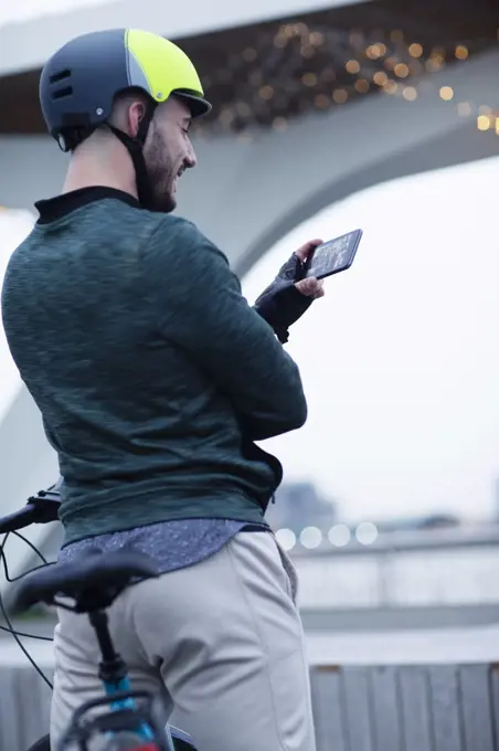 Man in bike helmet video chatting with smart phone
