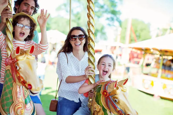 Family on carousel in amusement park