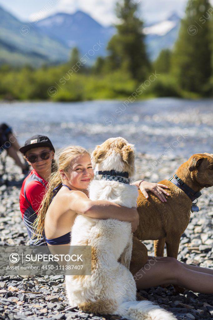 13 year old teen girl embracing her dog, CO., Crested Butte - SuperStock