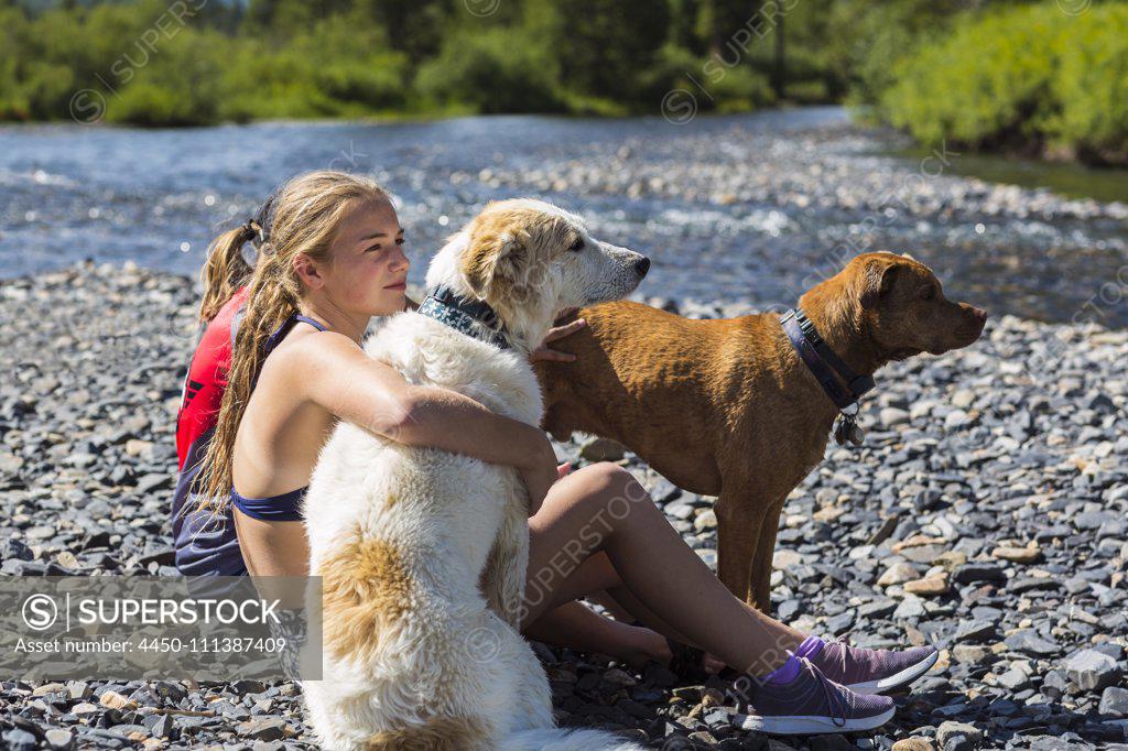 13 year old teen girl embracing her dog, Crested Butte, CO. - SuperStock