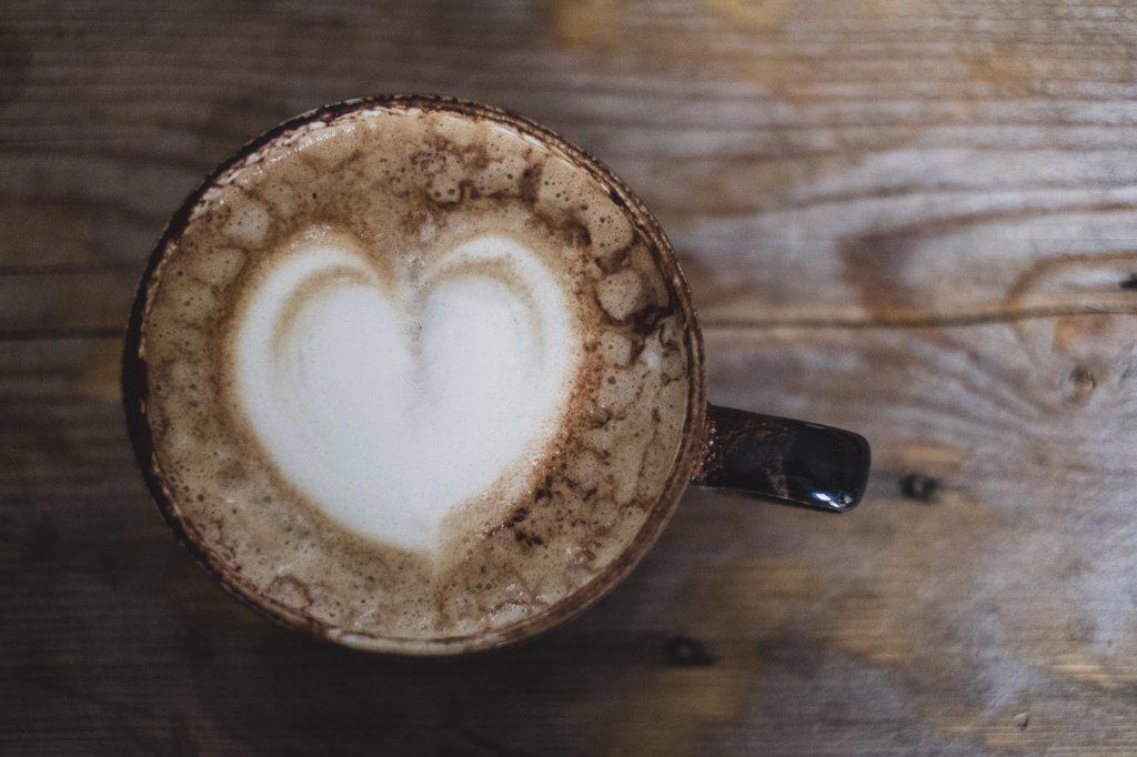 High angle close up of cappuccino topped with foam heart.