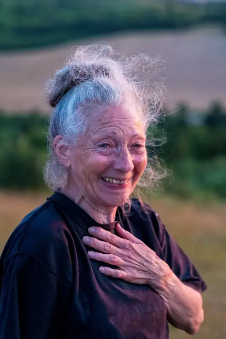 Senior woman taking part in a yoga class on a hillside.