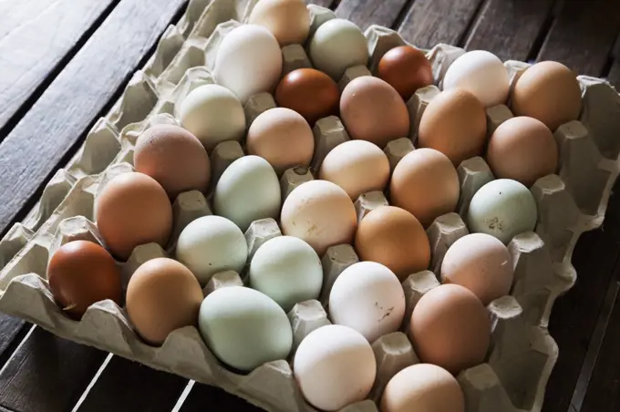 A tray of fresh organic eggs, in a variety of colours.