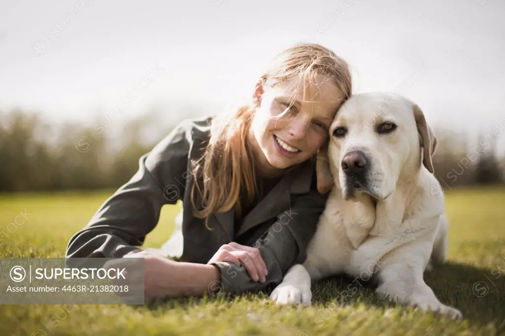 Smiling teenage girl with her Labrador dog.