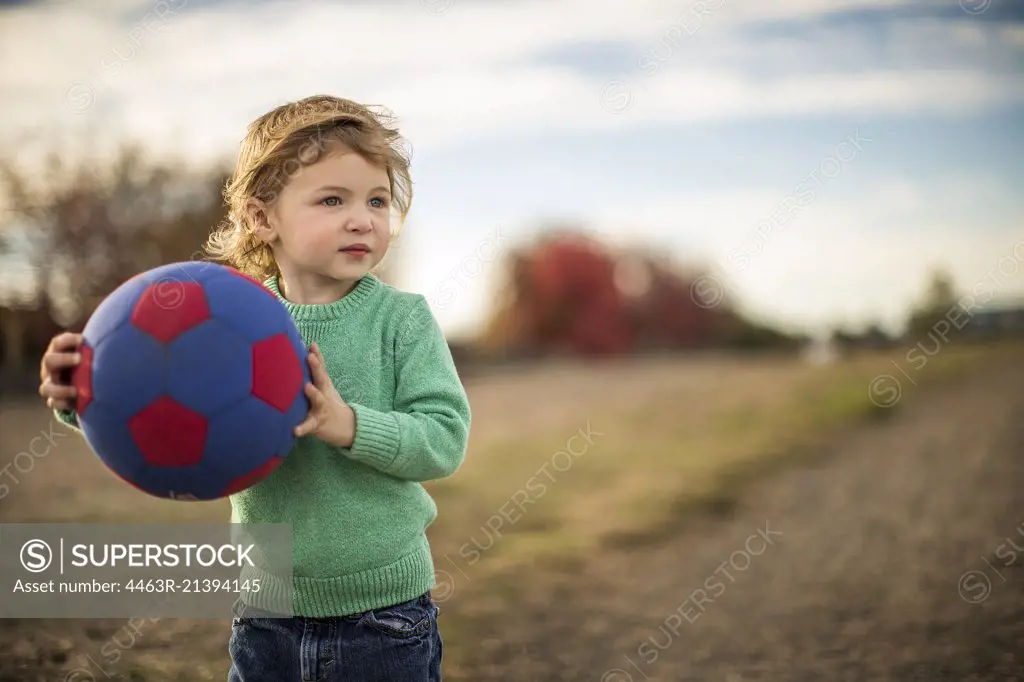 Young boy playing with ball.