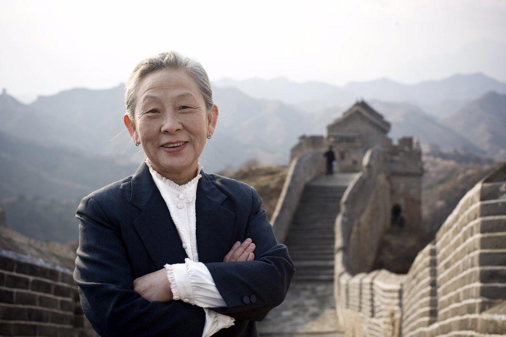 Portrait of a senior business woman standing on the Great Wall of China.