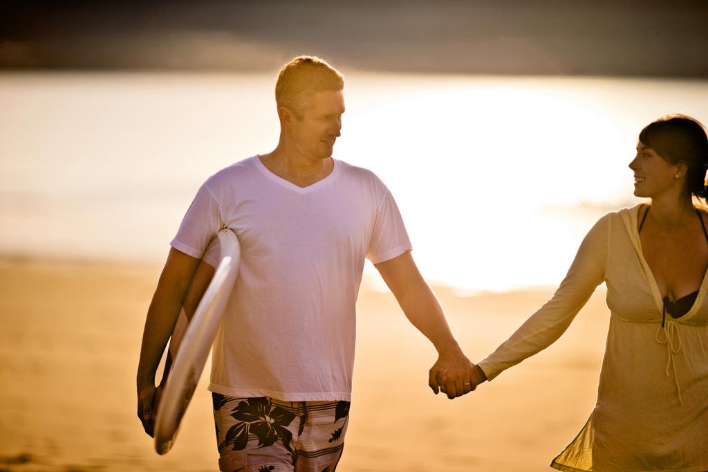 Middle aged couple walking hand in hand on the beach.