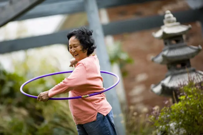 Older woman playing with hula hoop