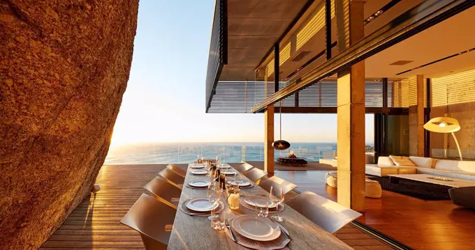 Modern luxury patio dining table with sunset ocean view