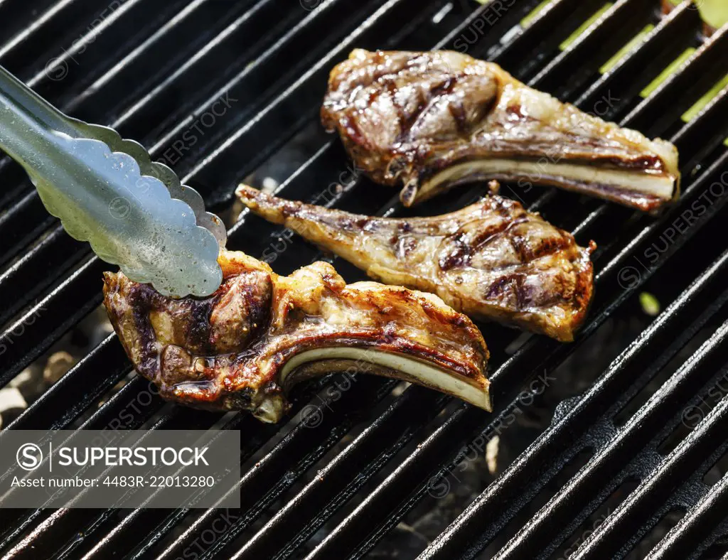 Grilled lamb ribs on cast iron grill BBQ background